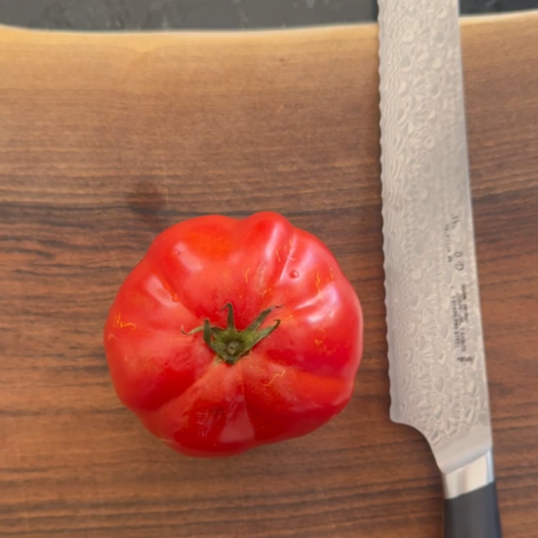 Reife Ochsenherz Tomate aus eigener Ernte wird zum Verarbeiten aufgeschnitten